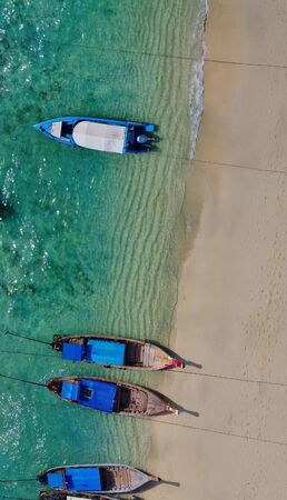Aerial view of long tail boats along a tropical beach, Thailand.の写真素材