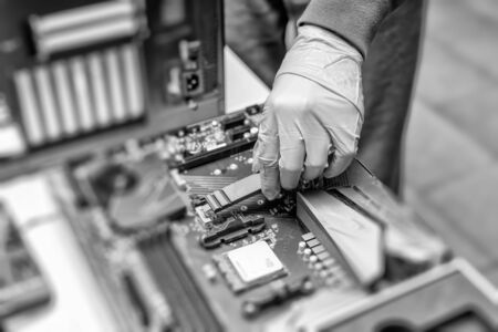Engineer connects the SSD hard drive to the computer.の写真素材