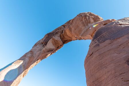 Skyward view of Delicate Arch, Arches National Park. Rock formation and blue sky, USAの写真素材
