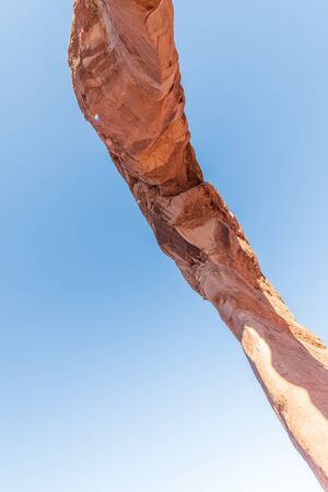 Skyward view of Delicate Arch, Arches National Park. Rock formation and blue sky, USAの写真素材