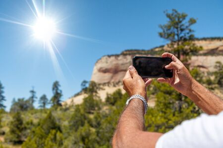 Tourist photographing natural landscape with the smartphone. Holiday and vacation concept.の写真素材