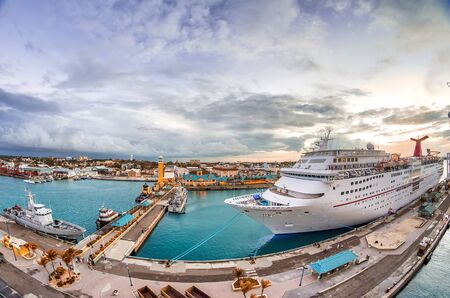 Cruise ship docked at caribbean port. Big ocean liner leaving a port at sunset.の写真素材