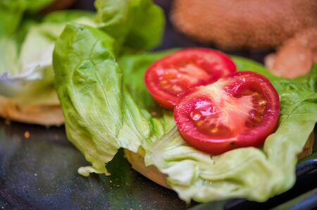 Tasty hamburger prepared on the table, closeup of tomatoes.の写真素材