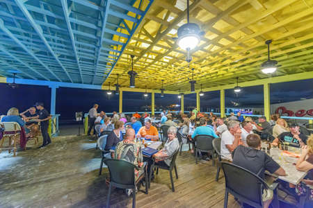 FORT MYERS, FL - FEBRUARY 2016: Tourists enjoy city life at night in a restaurant.のeditorial素材