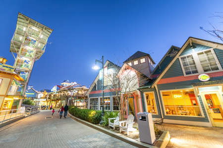 DESTIN, FLORIDA - FEBRUARY 2016: Destin Harbor Boardwalk at sunset with shops and tourists.のeditorial素材