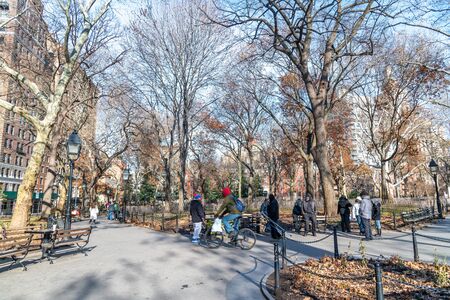 NEW YORK CITY - DECEMBER 6, 2018: Homeless people walk in a city park. Poverty is growing in New York City.の写真素材