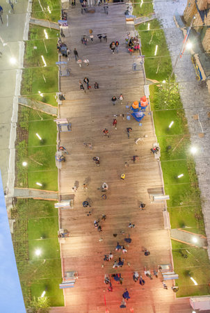 Downward aerial view of people relaxing in the city park at night.