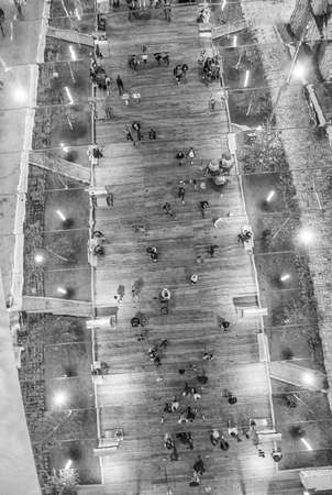 Downward aerial view of people relaxing in the city park at night.の写真素材