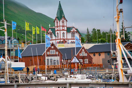 HUSAVIK, ICELAND - AUGUST 5, 2019: Husavik colorful homes and city port in Iceland. View on a cloudy summer afternoon.のeditorial素材