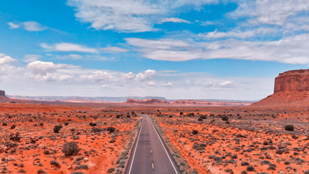 Countryside road through the fabulous Monument Valley in summser season, aerial view from drone.
