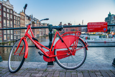 AMSTERDAM, THE NETHERLANDS - APRIL 25, 2015: Traditional houses and buildings on the canal with boats on the water.の写真素材