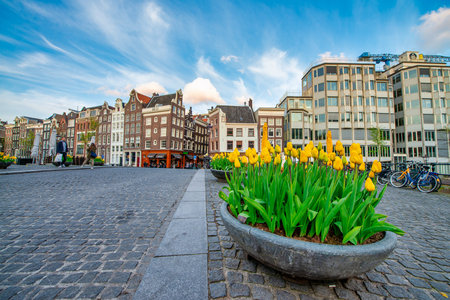 AMSTERDAM, THE NETHERLANDS - APRIL 25, 2015: Traditional houses and buildings on the canal with boats on the water.の写真素材