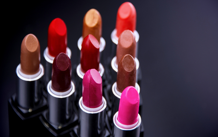 Make-up concept. Lipgloss. Lipsticks closeup Lipstick. Fashion Colorful Lipsticks over black background. Lipstick tints palette, Professional Makeup and Beauty. Beautifulの写真素材