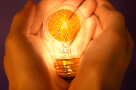 Hands holding lamp with orange and background with orange light illumination.の写真素材