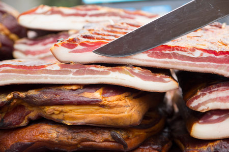 Home made smoked bacon in a street market, selective focus and small depth of field