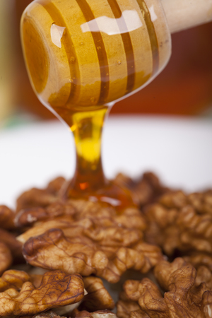 Walnuts topped with honey on a light backgroundの写真素材