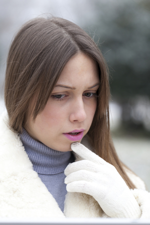 Portrait of upset and worried young woman standing in the parkの写真素材