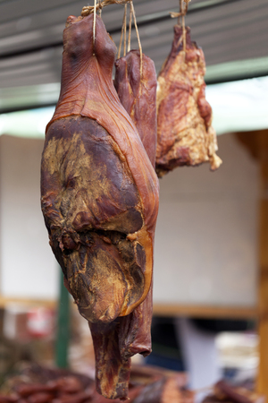 Home-made smoked ham hanging in the stalls, selective focus and small depth of fieldの写真素材