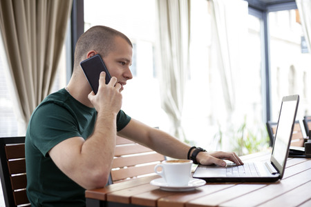 Student telephone and surf the Internet in cafe. Drink coffee.の写真素材
