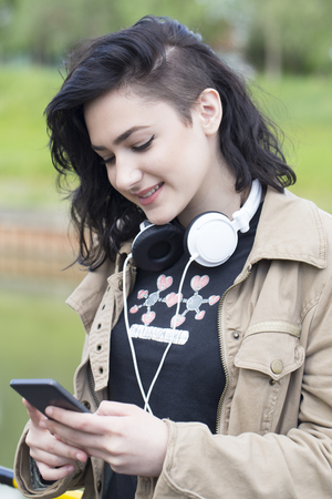 Young beautiful woman hipster texting messages on a mobile phoneの写真素材