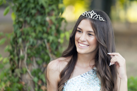 Beautiful young smiling woman posing with a crown on her headの写真素材