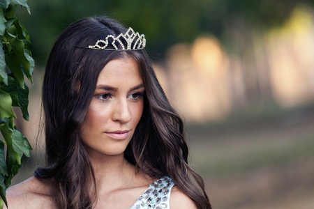 Beautiful young smiling woman posing with a crown on her head.Copy spaceの写真素材