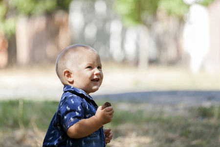 Close up portrait of a sweet little boy outside. He plays on a beautiful sunny summer day. Copy spaceの写真素材