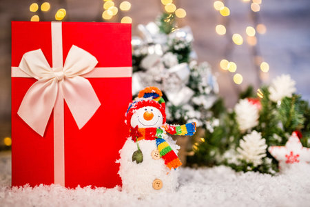Christmas decoration on a wooden background with snowman, snow and  lights in the background.  Happy New Year.Copy spaceの写真素材