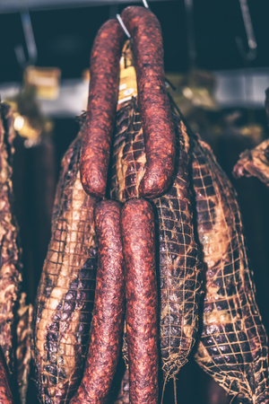 Delicious pieces of smoked meat and sausages exposed for sale in the market. Selective focus and small depth of fieldの写真素材