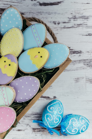 Easter homemade gingerbread cookies on wooden table. Beautiful glazed eggs. Greeting card. View from...