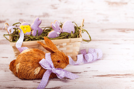 Beautiful glazed easter gingerbread cookies in a basket and rabbit on wooden table. Rabbit and egg....