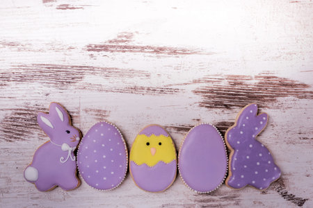 Easter gingerbread cookies on wooden table. Rabbits and eggs. Greeting card. View from above.Copy...