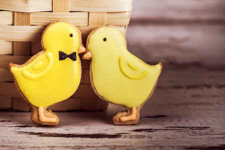 Beautiful glazed easter gingerbread cookies chicks on wooden table. Greeting card. View from...