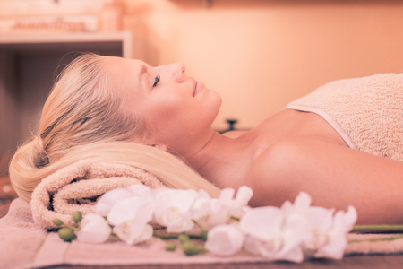 Close up shot of an attractive young woman enjoying a relaxing massage at the spaの写真素材