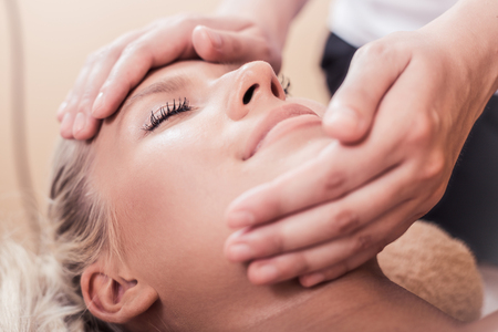 Close up shot of a young woman enjoying a head massage at a spaの写真素材