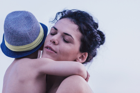 Happy mother with her son enjoy the beautiful sunny day on the beach. Mother hugging her son. Positive human emotions, feelings, joy. Happy familyの写真素材