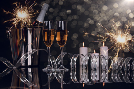 Two wine glasses with champagne, bottle and Christmas sparklers on a black background. Copy space. Merry Christmas and Happy New Year, backgroundの写真素材