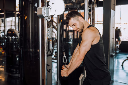 Closeup of a muscular young man lifting weights. - Image