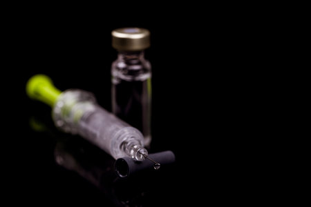 Medical vials for injection with a syringe and ampules on black background - Image