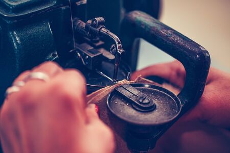 Female shoemaker hands stitching a part of the shoe at a workshopの写真素材