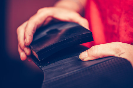 Hands of an experienced cobbler in the handmade footwear industry, is fixing sole for shoes.の写真素材