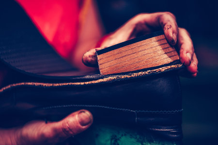 Hands of an experienced cobbler in the handmade footwear industry, is fixing sole for shoes.の写真素材