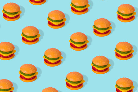 Creative trendy idea fast food pattern-  Hamburger on bright blue background. Minimal junk food concept. Abstract creative food concept with gummy candies.の写真素材