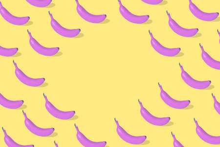 Trendy Summer food  pattern made with fresh banana fruit colored in pink on illuminating yellow background. Minimal summer food concept. Free space for textの写真素材