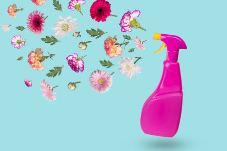 Creative minimal idea made from a bottle with a spray and various flowers flying in the air. The...