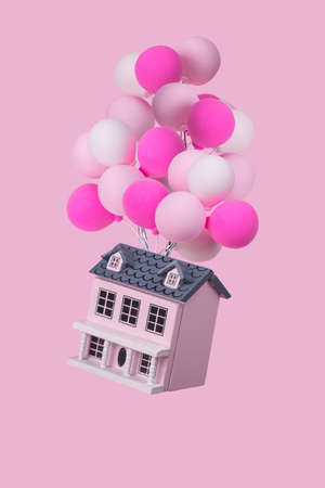 Creative idea with a house with a lot of colorful balloons flying in the air. Minimal concept for advertising, marketing or artwork design.の写真素材