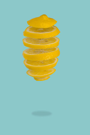 Floating levitating fresh lemon on pastel blue background. Vitamins, healthy diet concept. Minimal fruit idea. Sliced lemon floating in the air. Creative concept with flying fruits with space for text.