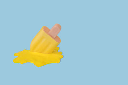 Yellow stick ice cream melting on pastel blue background. Creative idea, minimal summer concept. Copy spaceの写真素材