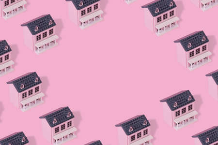 Trendy pattern made with pink wooden  house on a pastel pink background. Minimal creative concept with copy space.の写真素材