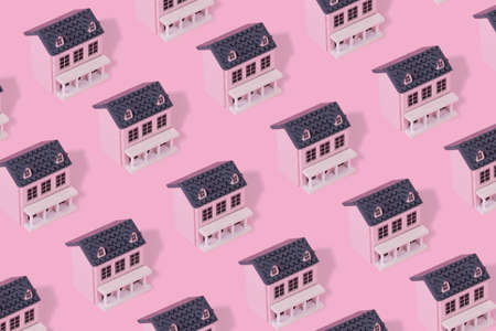 Modern pattern made with pink wooden house on a pastel pink background. Minimal creative concept.の写真素材